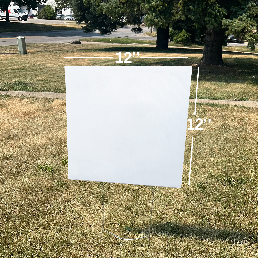 A 12x12 inch blank white RAYGUN yard sign with metal stakes in the ground, marked with dimension lines showing its width and height.
