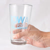 A hand holds a dishwasher-safe Iowa pint glass printed with the words IOWA 75% VOWELS 100% AWESOME in blue soy-based ink.