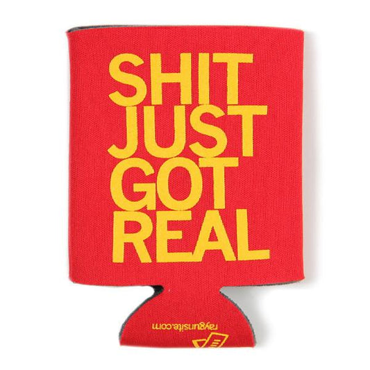 Red foam can cooler with yellow RAYGUN text reading SHIT JUST GOT REAL and a small website URL at the base.