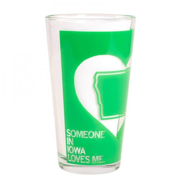 Clear dishwasher-safe pint glass featuring a green heart-shaped graphic of Iowa with the text SOMEONE IN IOWA LOVES ME.