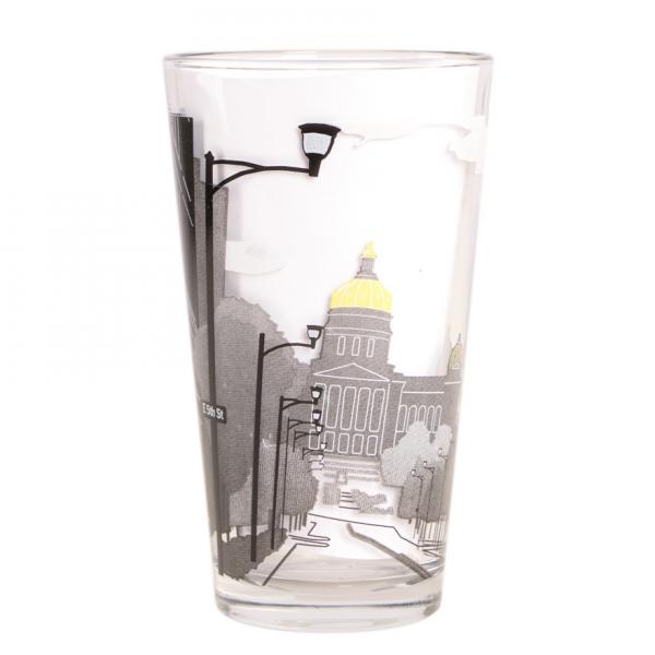Clear pint glass featuring a black-and-white, soy-based ink graphic of a city street leading toward an Iowa Capitol building with a gold dome.