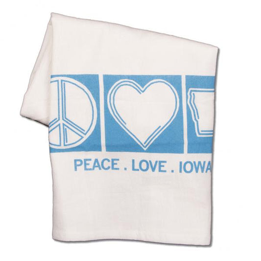 White flour sack towel featuring a blue design of a peace sign, heart, and the state of Iowa, with the text PEACE . LOVE . IOWA printed below.