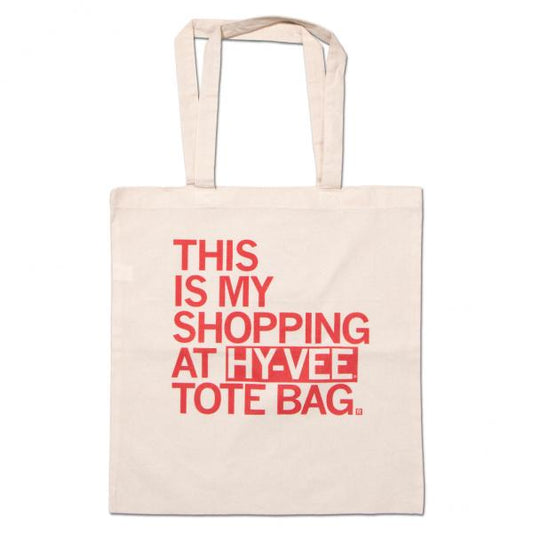 Off-white canvas grocery bag with red text that reads, THIS IS MY SHOPPING AT HY-VEE TOTE BAG.