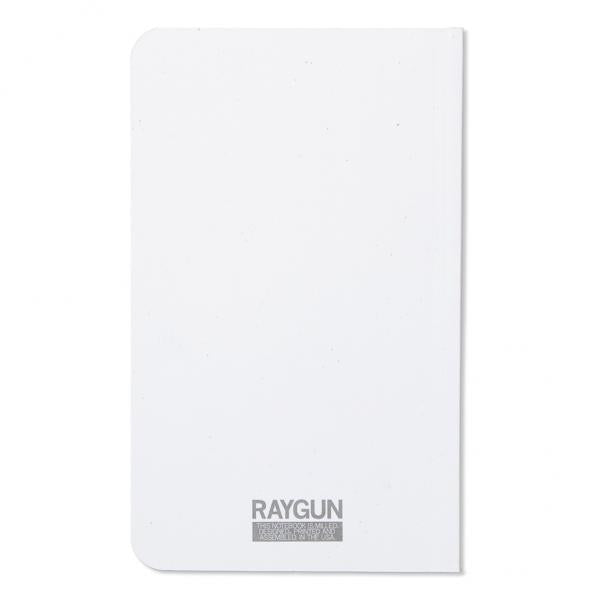 White notebook with a screen-printed Raygun logo and text at the bottom.