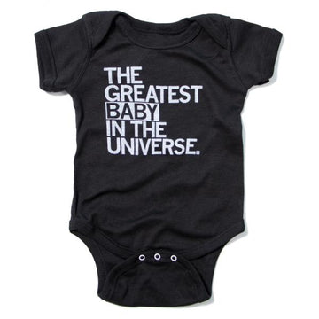 Black, 100% cotton baby onesie featuring white text that reads, THE GREATEST BABY IN THE UNIVERSE.