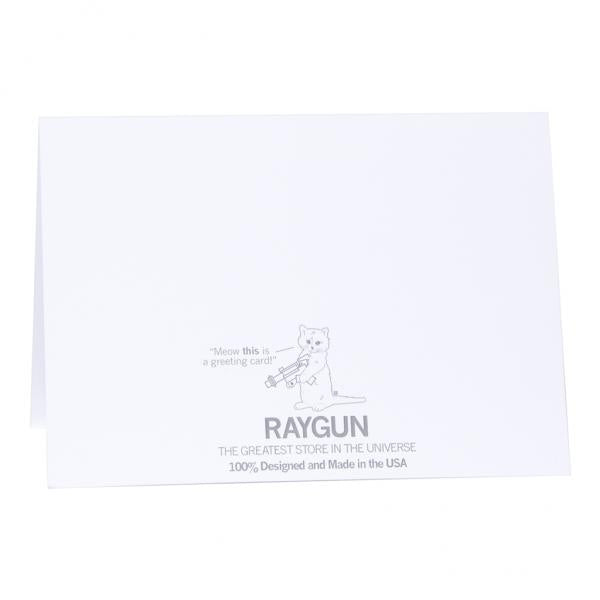 Back of a greeting card with a small illustration of a cat holding a ray gun, the text Meow this is a greeting card!, the Raygun store logo, and THE GREATEST STORE IN THE UNIVERSE 100% Made in the USA.