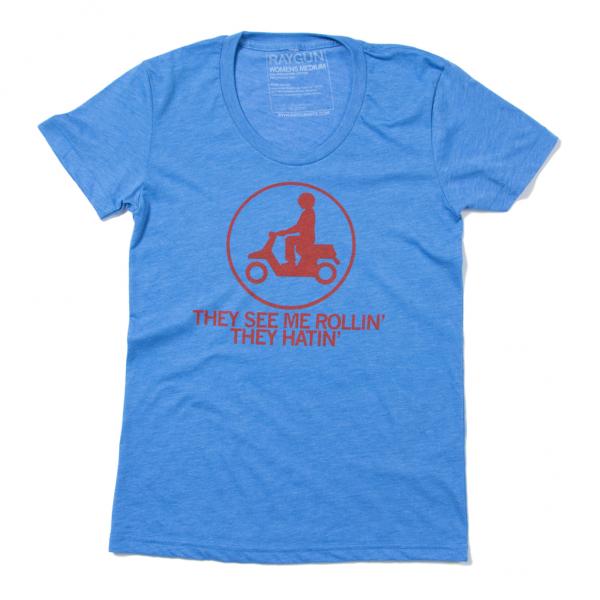 Blue Raygun short-sleeved t-shirt with a red circular graphic of a person on a scooter and the text THEY SEE ME ROLLIN THEY HATIN.