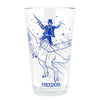 A dishwasher-safe pint glass featuring a blue graphic of a man in a top hat riding a T-Rex while holding a rifle and a knife, with the word FREEDOM. printed at the base in navy soy-based ink.