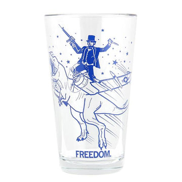 A dishwasher-safe pint glass featuring a blue graphic of a man in a top hat riding a T-Rex while holding a rifle and a knife, with the word FREEDOM. printed at the base in navy soy-based ink.