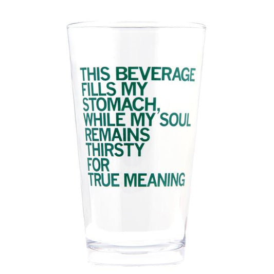 A clear, dishwasher-safe pint glass printed with the green text: THIS BEVERAGE FILLS MY STOMACH, WHILE MY SOUL REMAINS THIRSTY FOR TRUE MEANING.