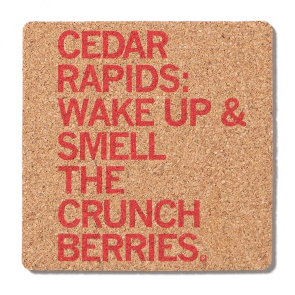 Square cork coaster featuring red text that reads, CEDAR RAPIDS: WAKE UP & SMELL THE CRUNCH BERRIES.