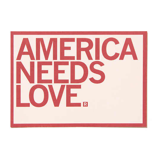 Rectangular America Needs Love postcard sign reading the title in red, bold, sans-serif letters, with a registration symbol after the word LOVE.