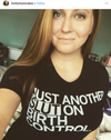 A woman wearing a union-made black t-shirt that says JUST ANOTHER SLUT ON BIRTH CONTROL.