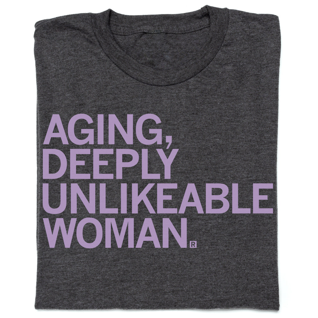 Charcoal t-shirt featuring the lavender text: AGING, DEEPLY UNLIKEABLE WOMAN.