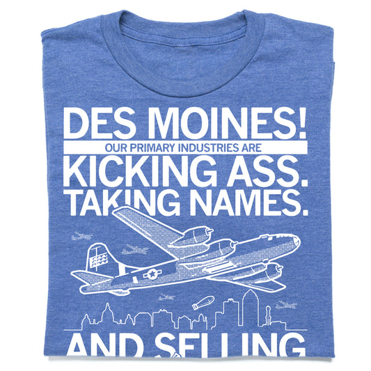 Blue union made t-shirt featuring the text DES MOINES! OUR PRIMARY INDUSTRIES ARE KICKING ASS. TAKING NAMES. AND SELLING above a graphic of an airplane and a city skyline.