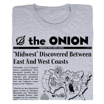 Gray The Onion t-shirt featuring a satirical headline reading, Midwest Discovered Between East And West Coasts, with an illustrated map of the United States.
