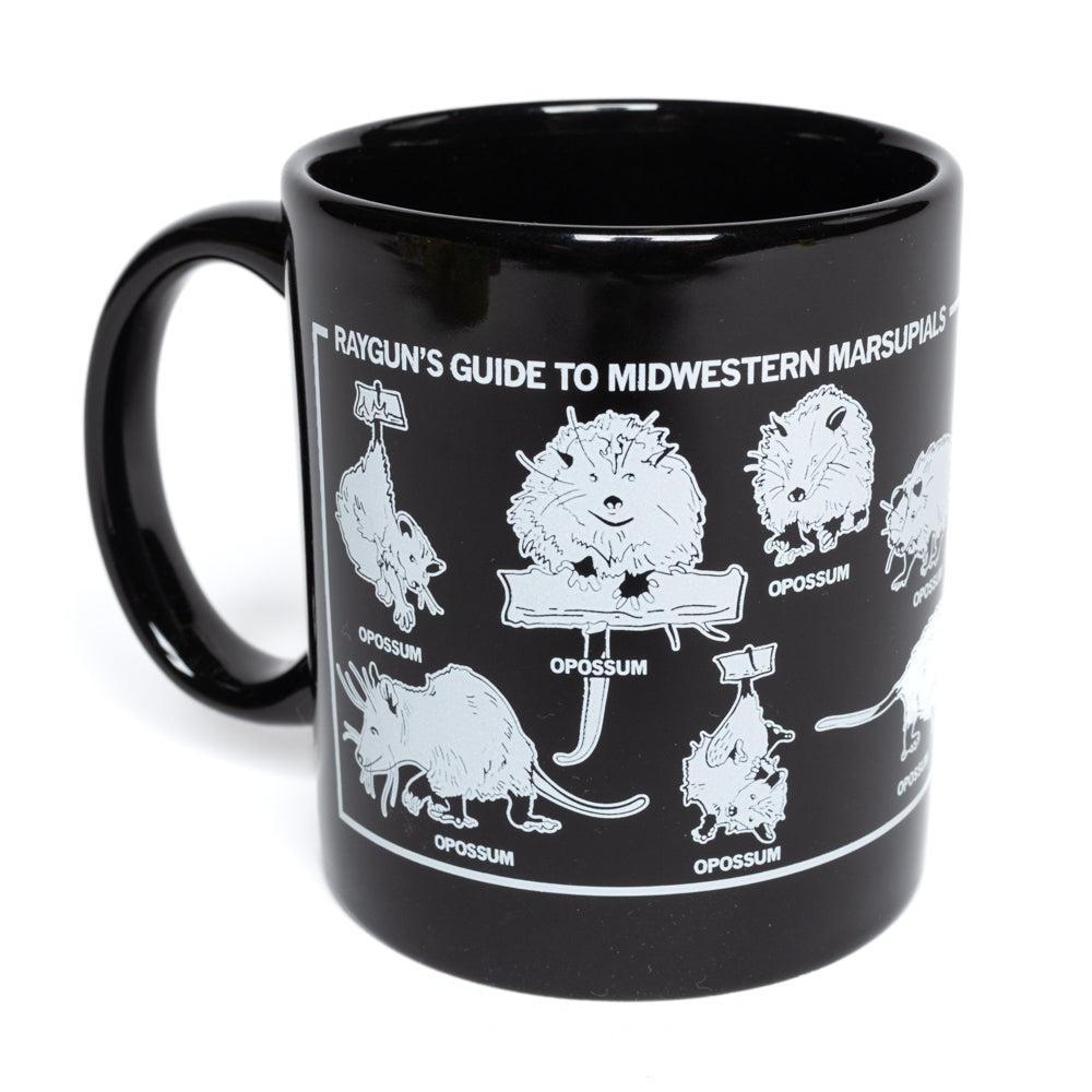 Black 11 oz RAYGUN mug with a white graphic titled Rayguns Guide to Midwestern Marsupials featuring various illustrations of opossums.