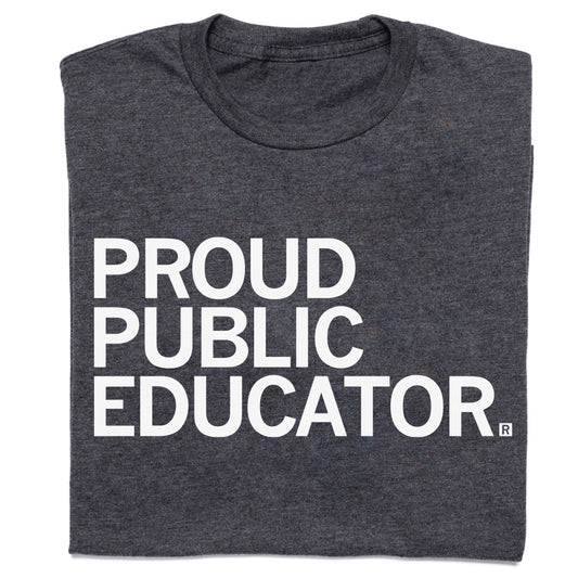 A folded charcoal t-shirt with white text that reads "Proud Public Educator"