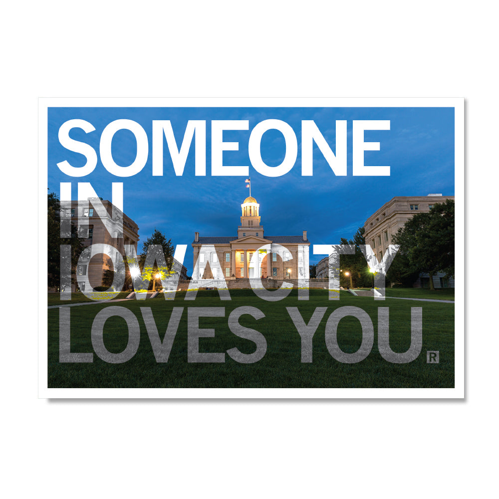 The University of Iowa Old Capitol building at dusk, featuring the text SOMEONE IN IOWA CITY LOVES YOU in a style reminiscent of a RAYGUN Iowa City postcard.