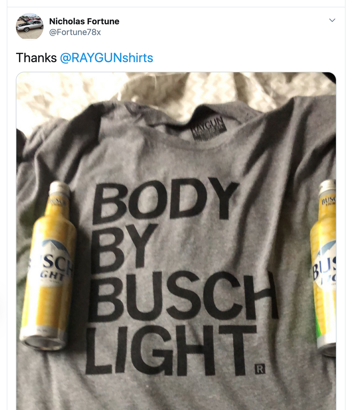 A heather grey Busch Light t-shirt printed with the text BODY BY BUSCH LIGHT, flanked by two cans of beer.