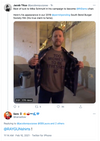 A man in a room holds open a dark jacket to reveal a union-made Midwest T-shirt that reads TOO MIDWEST TO BE STRESSED.