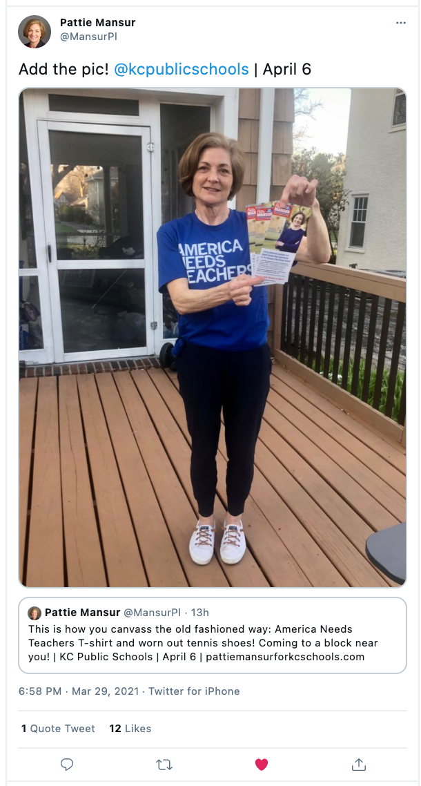 A woman in a union-made blue T-shirt that says America Needs Teachers holds a campaign flyer while standing on a wooden deck to show her support for public education.
