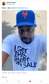 A person wearing a blue New York Mets baseball cap and a white screen print t-shirt that says I GOT THIS SHIRT ON SALE.