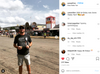 A man wearing a charcoal T-shirt that defines chi-owan stands at the Iowa State Fair in front of food stands.