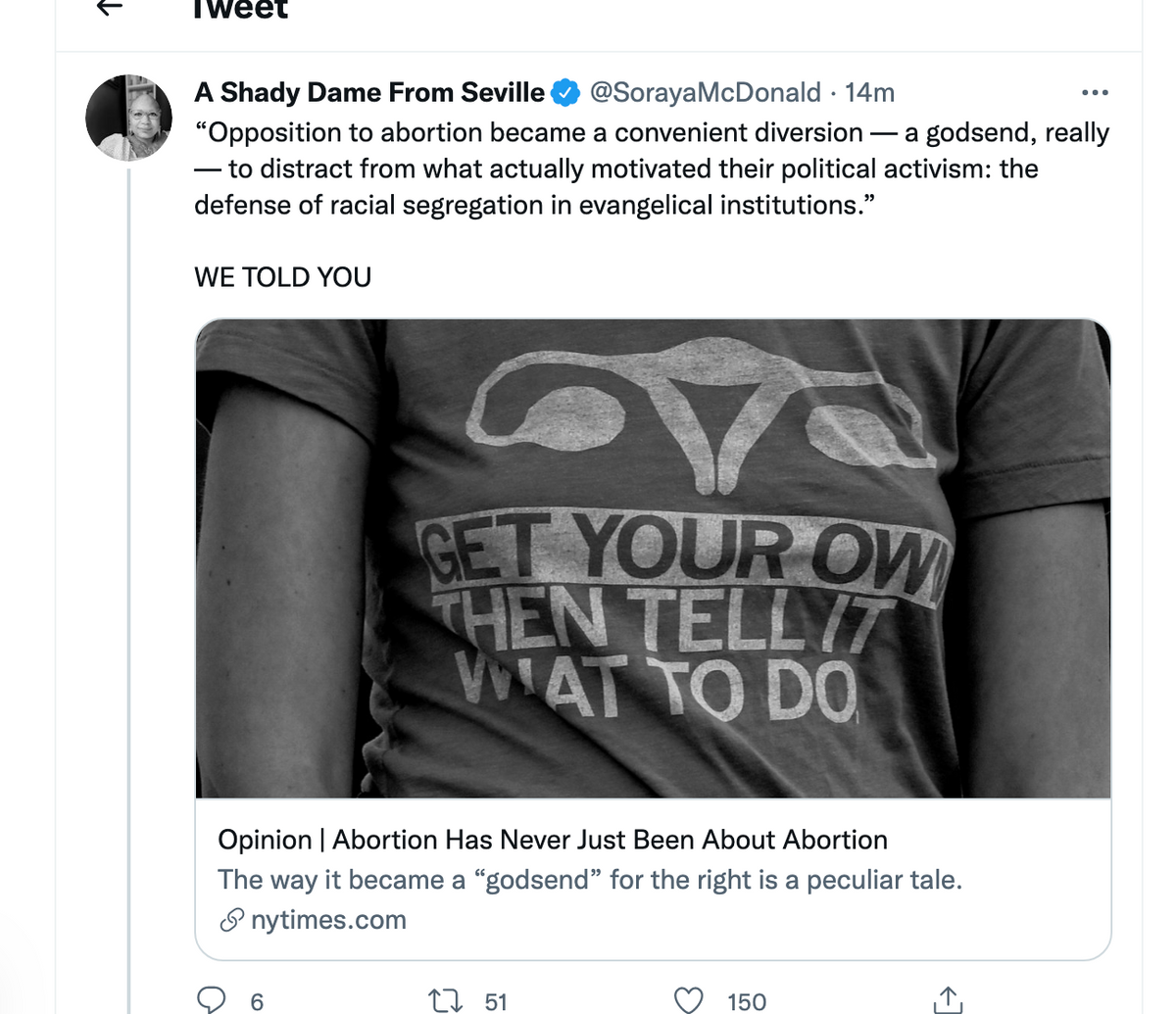 A person wears a sweatshop-free t-shirt featuring a stylized uterus icon and the text GET YOUR OWN THEN TELL IT WHAT TO DO below a New York Times article link.