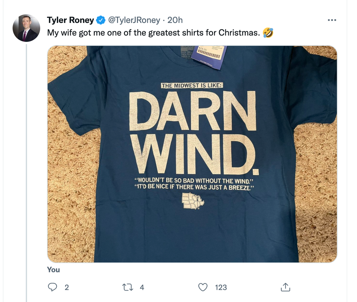 A cool blue Midwest T-shirt featuring a map of the United States and the text: The Midwest is like: Darn wind. Wouldn’t be so bad without the wind. It’d be nice if there was just a breeze.