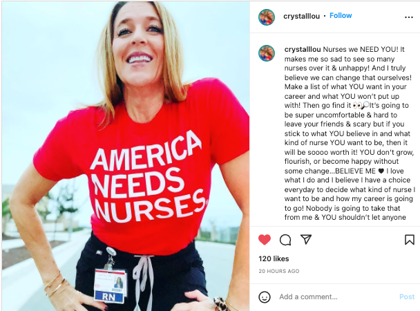 A smiling woman wears a red t-shirt that says America Needs Nurses with an RN identification badge clipped to her pants.