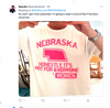A person wearing a neon pink, union-made t-shirt that says NEBRASKA, HONESTLY, ITS NOT FOR EVERYONE with a graphic of the state outline above the word WOMEN.