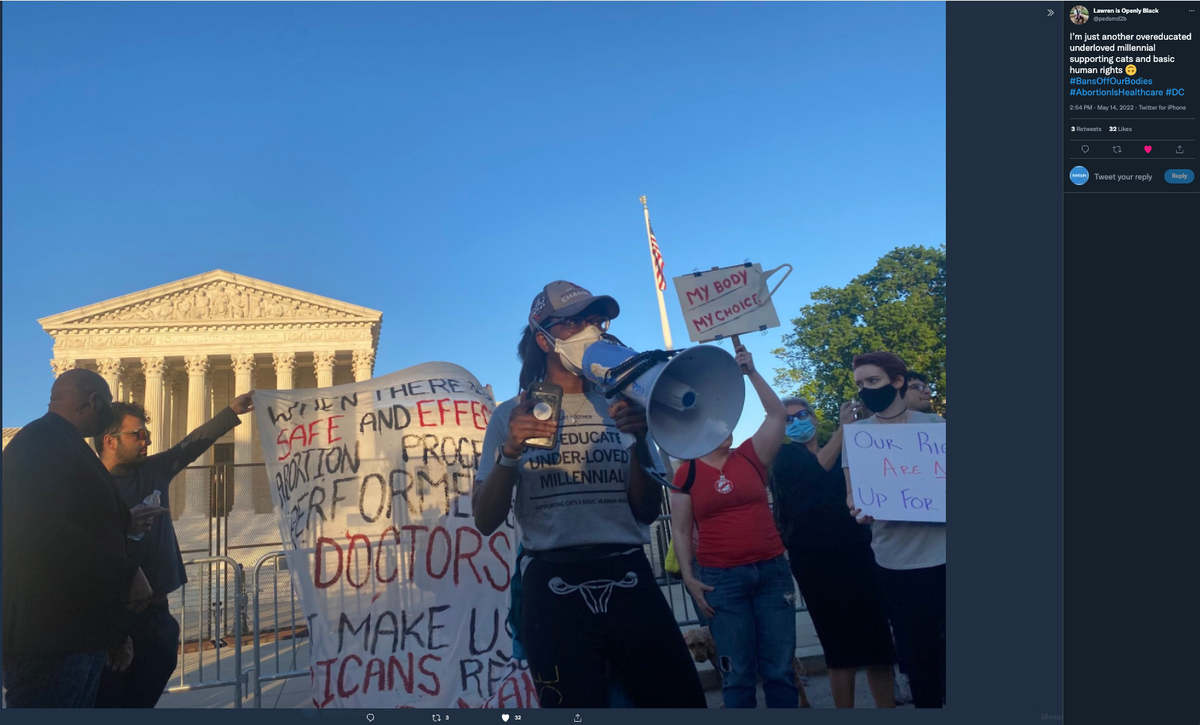 Protesters gather before the U.S. Supreme Court, where a speaker uses a megaphone as others hold signs reading My body my choice and Safe and effective abortion performed by doctors, with many wearing union made millennial t-shirts.