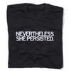 A folded black t-shirt with white ink text that reads "Nevertheless, She Persisted"