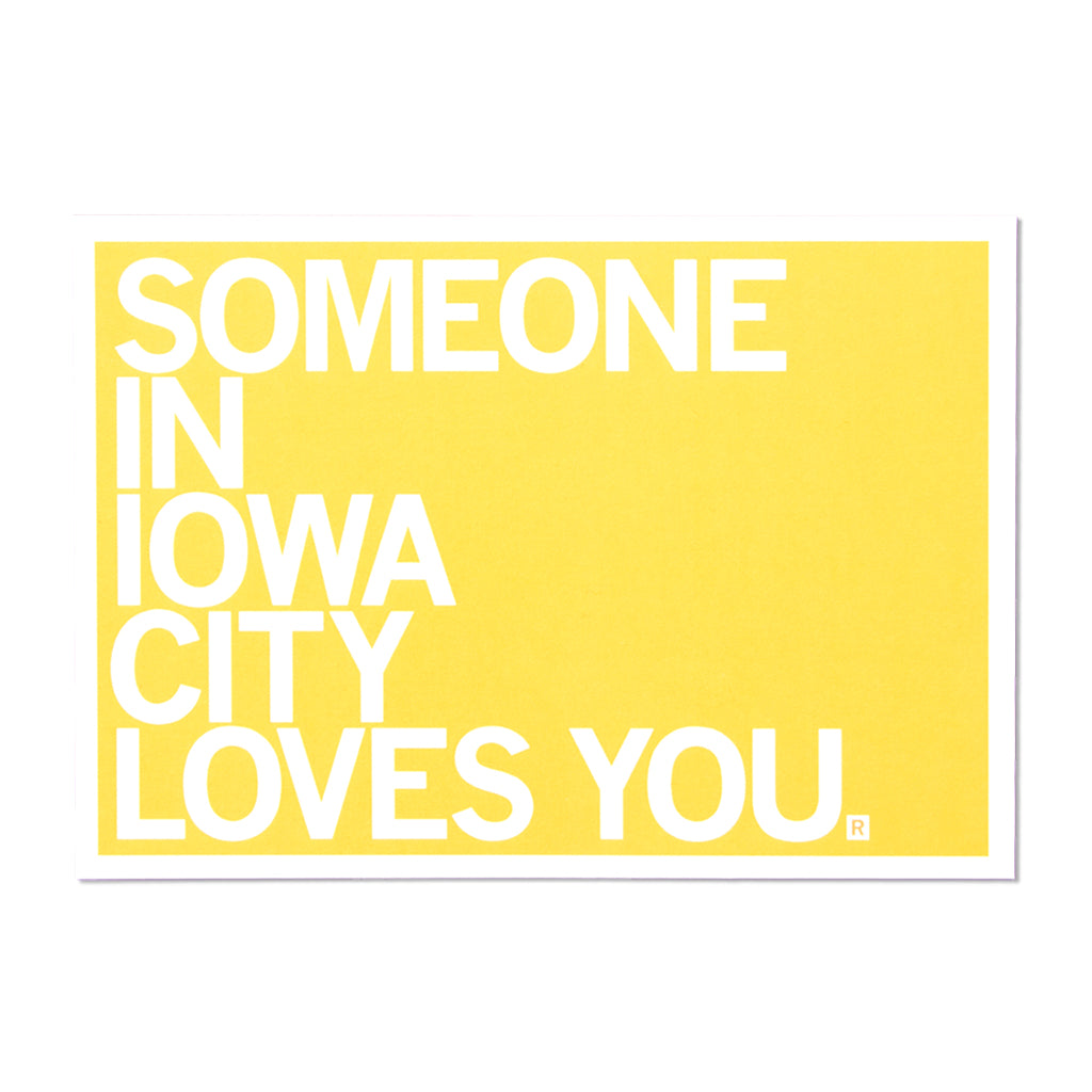 A yellow RAYGUN sign with white text that reads, SOMEONE IN IOWA CITY LOVES YOU.