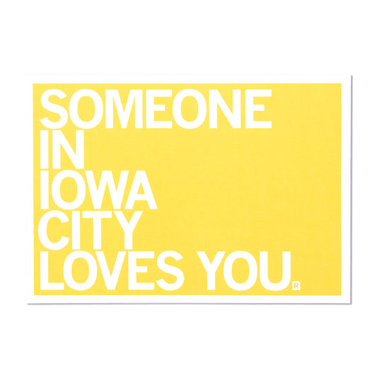 A yellow RAYGUN sign with white text that reads, SOMEONE IN IOWA CITY LOVES YOU.