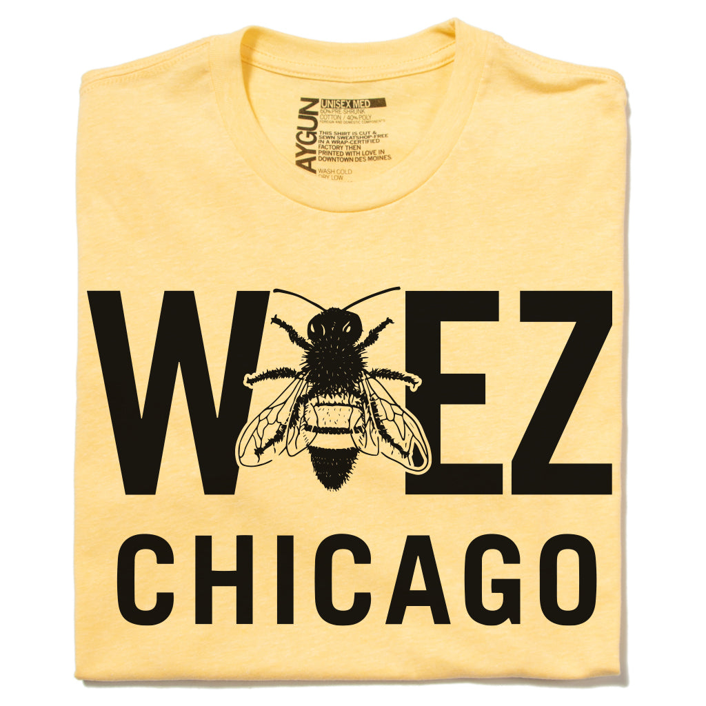 Yellow WBEZ merchandise t-shirt with WEEZ CHICAGO printed in black, featuring a bee graphic in place of the letter E.