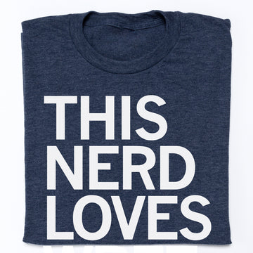 An officially licensed navy blue Raygun t-shirt with the text THIS NERD LOVES printed in large white capital letters.