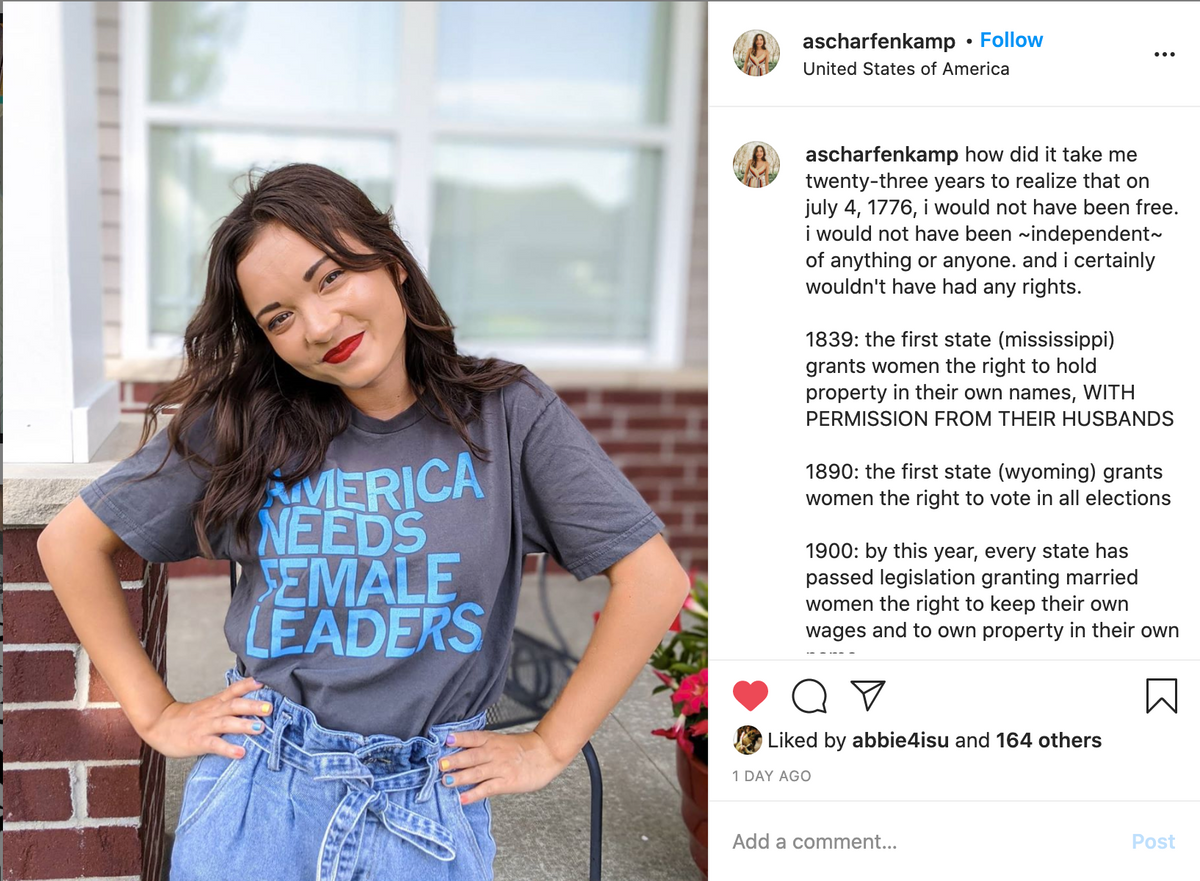 A woman wearing a union-made gray t-shirt with the text AMERICA NEEDS FEMALE LEADERS in blue letters.
