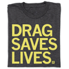 Folded charcoal T-shirt with the yellow text DRAG SAVES LIVES. printed on the front.