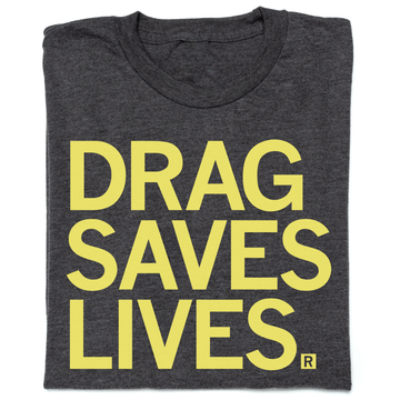 Folded charcoal T-shirt with the yellow text DRAG SAVES LIVES. printed on the front.