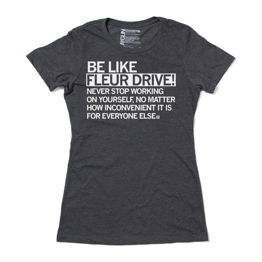Dark gray RAYGUN inspirational t-shirt with white text that reads, BE LIKE FLEUR DRIVE! NEVER STOP WORKING ON YOURSELF, NO MATTER HOW INCONVENIENT IT IS FOR EVERYONE ELSE.