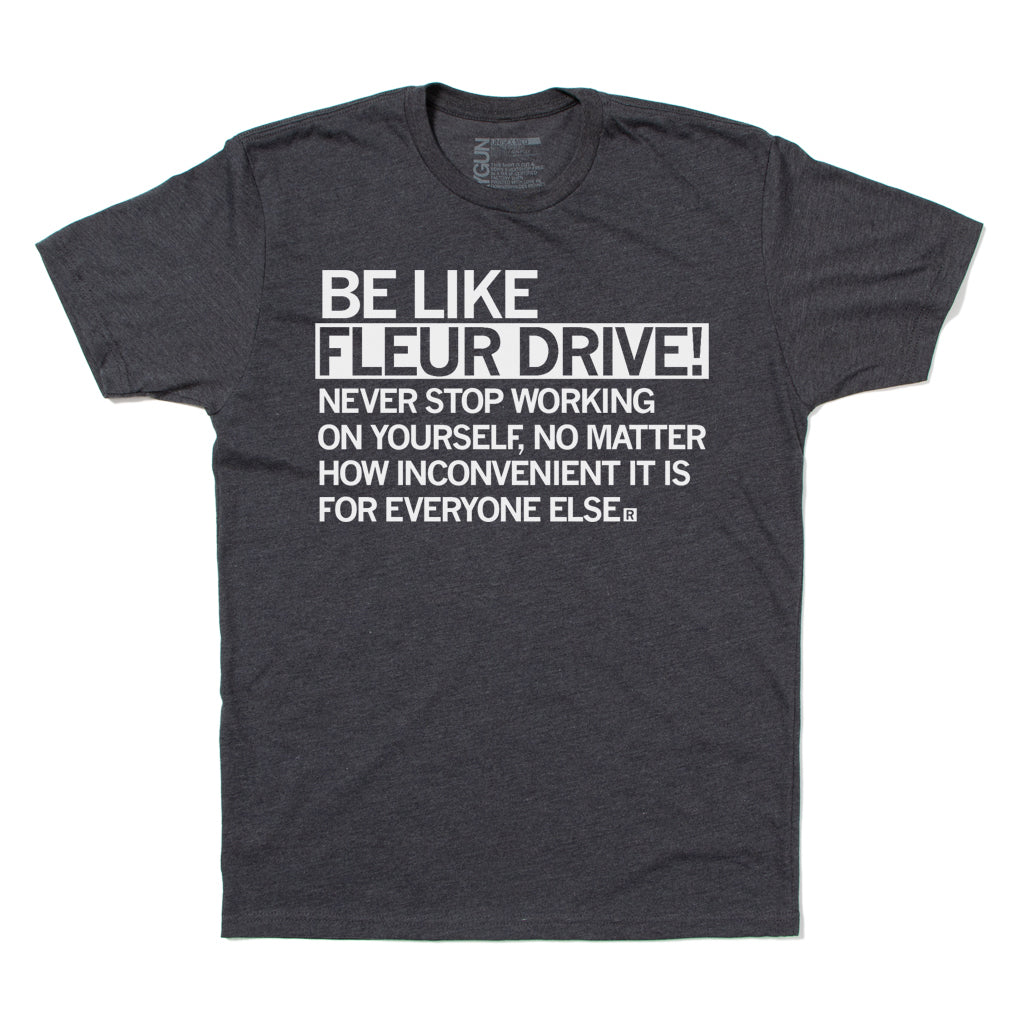 Dark gray RAYGUN apparel t-shirt with white text that reads: BE LIKE FLEUR DRIVE! NEVER STOP WORKING ON YOURSELF, NO MATTER HOW INCONVENIENT IT IS FOR EVERYONE ELSE.
