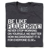 Charcoal gray RAYGUN inspirational t-shirt with white text that reads, BE LIKE FLEUR DRIVE! NEVER STOP WORKING ON YOURSELF, NO MATTER HOW INCONVENIENT IT IS FOR EVERYONE ELSE.