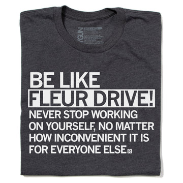 Charcoal gray RAYGUN inspirational t-shirt with white text that reads, BE LIKE FLEUR DRIVE! NEVER STOP WORKING ON YOURSELF, NO MATTER HOW INCONVENIENT IT IS FOR EVERYONE ELSE.