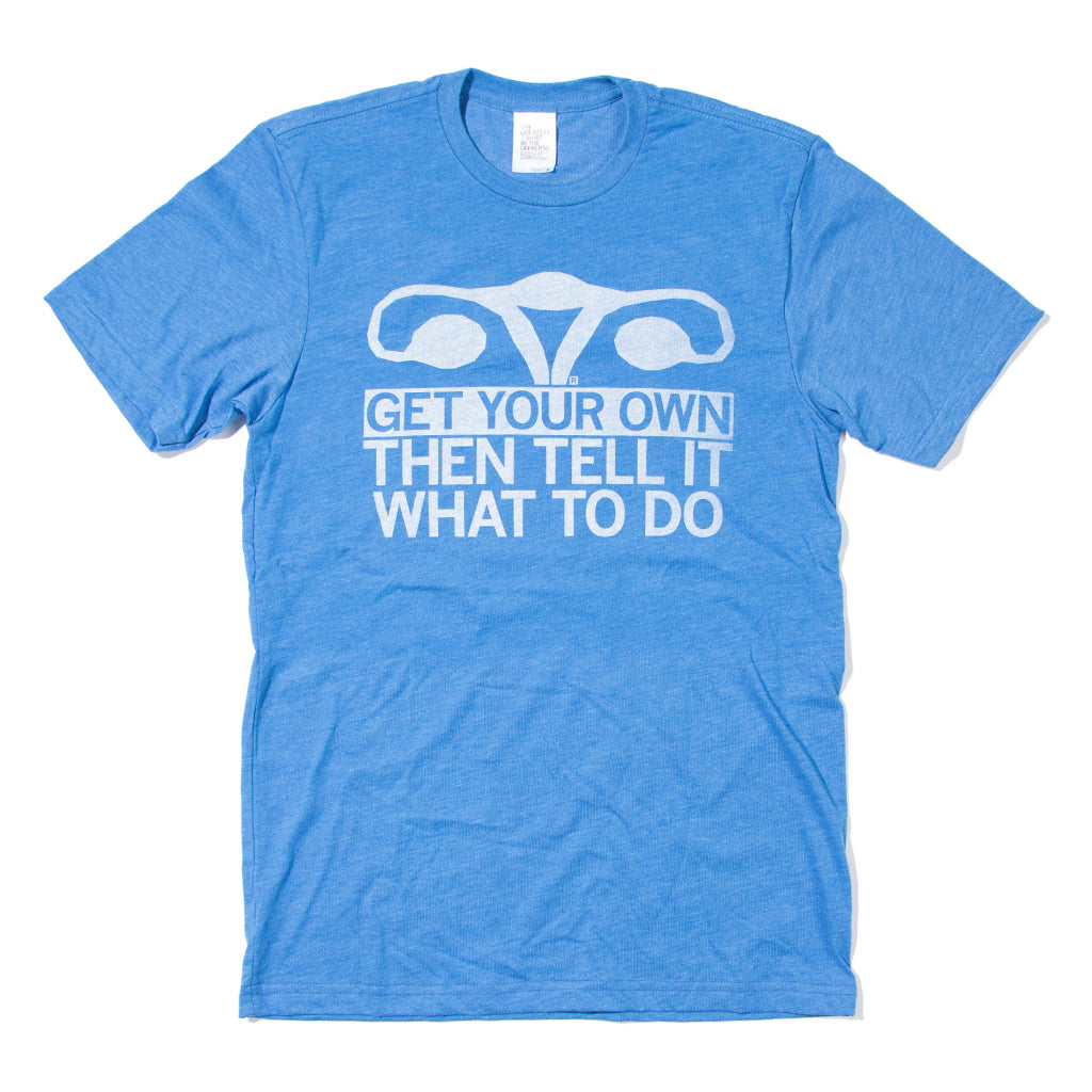 Heather blue t-shirt with white ink depicting a uterus with all caps text below that says, "Get Your Own, Then Tell It What To Do"