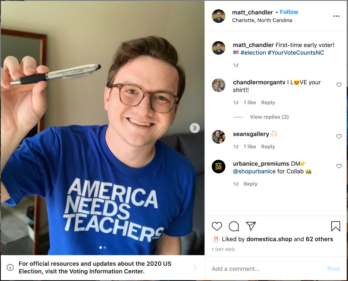 A young man wearing glasses and a blue AMERICA NEEDS TEACHERS t-shirt, supporting public education, holds up an I Voted pen.
