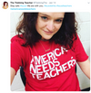 A woman wearing a union-made red t-shirt that says America Needs Teachers in large white letters.
