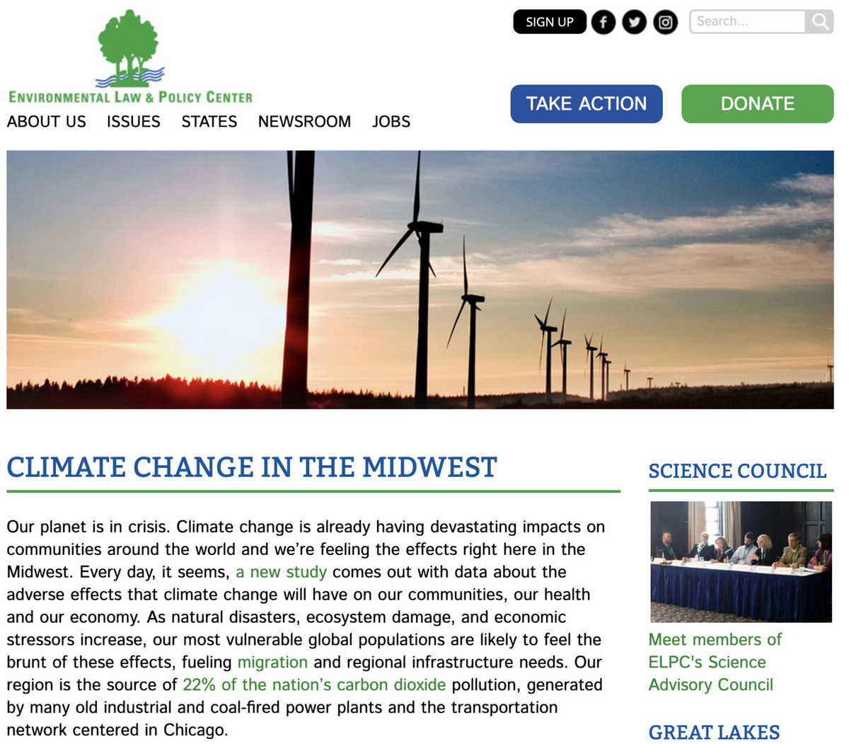 Wind turbines rise above an eco-friendly pollinator field at sunset in the Midwest.