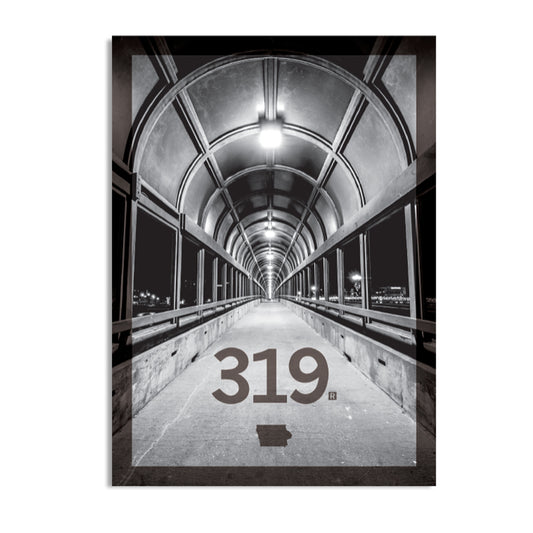 Black and white photo of a covered pedestrian bridge looking down a long, arched tunnel, with the 319 Iowa area code and the state’s shape printed in the foreground.